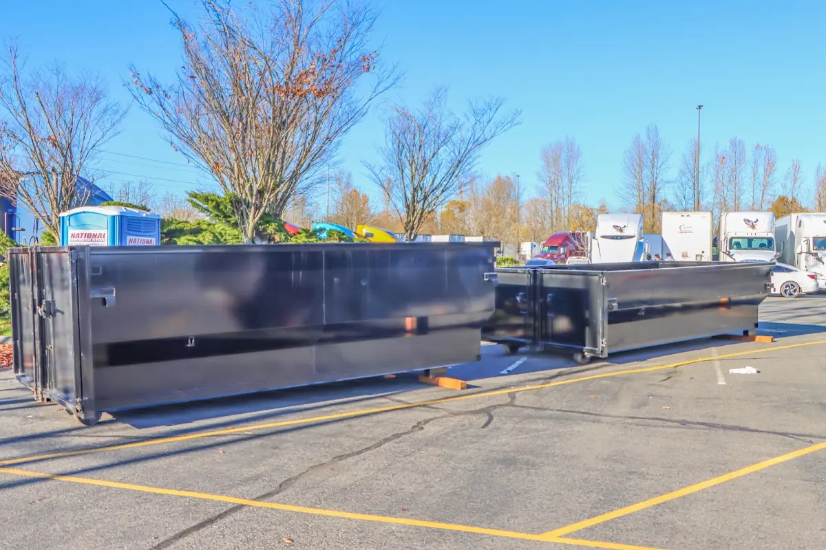 Professional dumpster rental service with roll-off container on residential driveway in Hyde Park